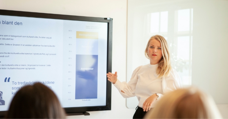Kvinne snakker for et publikum